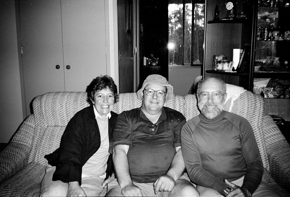 Kay, Derek and Alan sitting together on a sofa in a lounge room, early 1990s