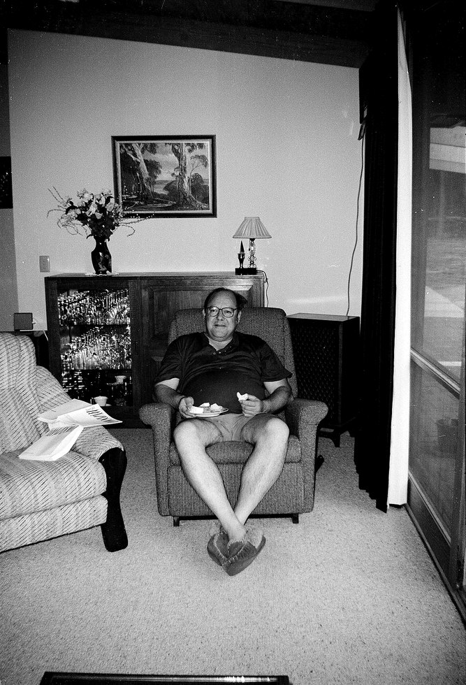 Derek Distel sitting in an armchair at home, feet up, in a lounge room