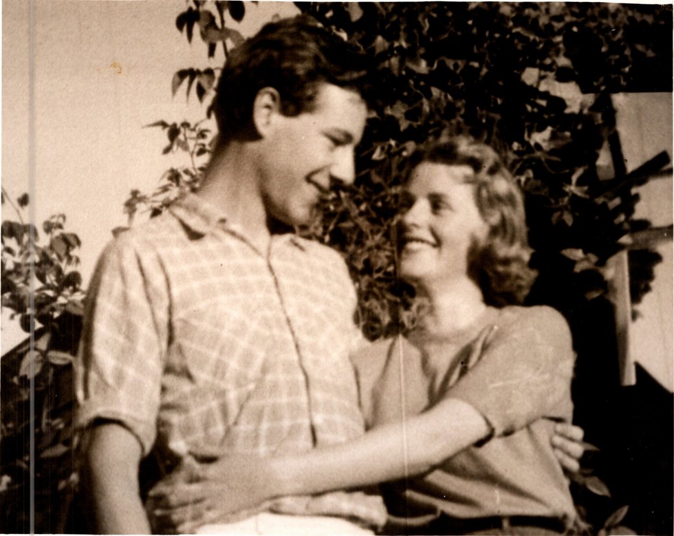 Derek and Pat as a young couple outdoors, embracing and laughing, late 1950s