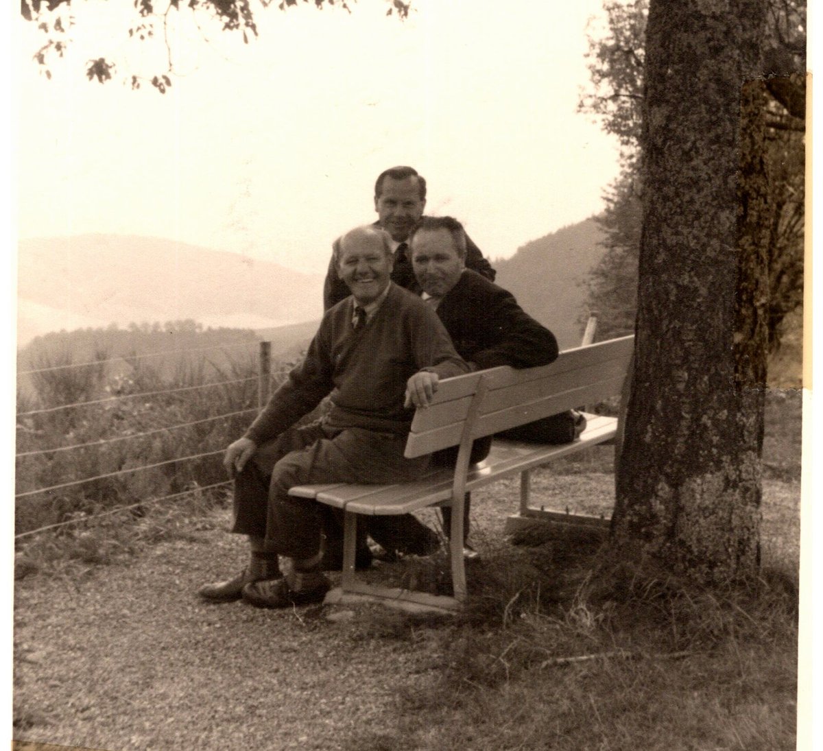 Three middle-aged men on a bench on a hillside in the Black Forest, 1965
